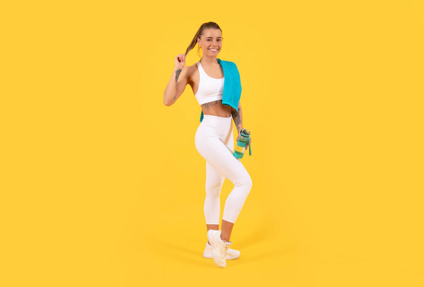 happy sport woman with water bottle on yellow background - Photo, Image