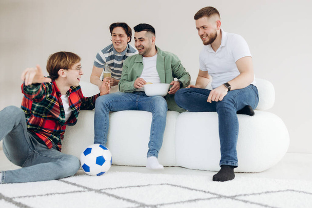 Μια ομάδα φίλων που παρακολουθούν έναν ποδοσφαιρικό αγώνα στην τηλεόραση. Φίλαθλοι ποδοσφαίρου - Φωτογραφία, εικόνα