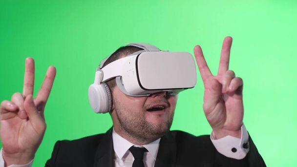 Trabajador de oficina baila felizmente con las manos en alto, utiliza gafas de realidad virtual - Foto, imagen