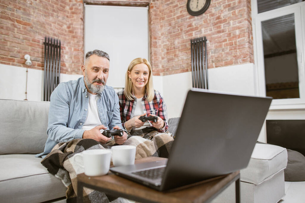 Cheerful mature couple playing video games at home - Fotoğraf, Görsel