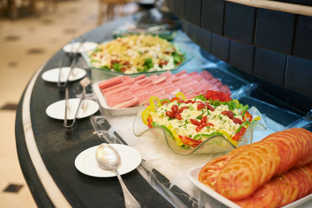 Escolhe o teu prato. Uma seleção de pratos em um balcão de buffet rotativo. - Foto, Imagem