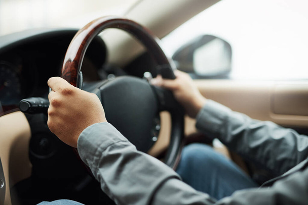 Driving solo. Shot of hands holding onto a steering wheel while driving. - Foto, imagen