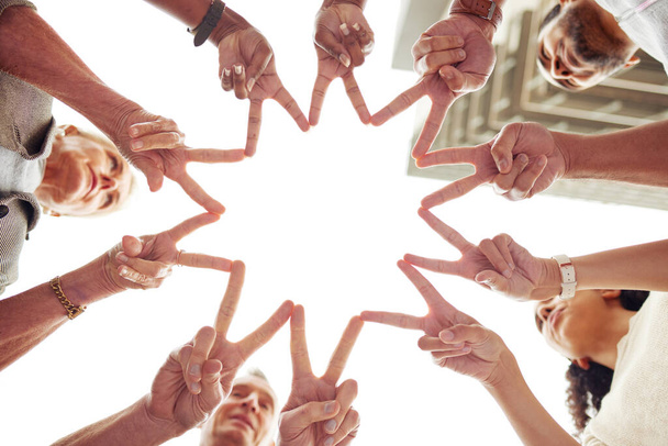 Were shooting for the stars. Low angle shot of a group of unrecognisable people making a peace sign with their fingers to create a star shape together. - Photo, Image
