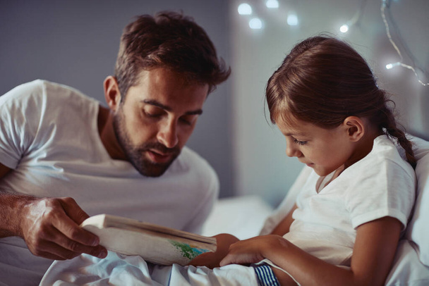 Günün en sakin ve sessiz yeridir. Bir babanın küçük kızına masal okuduğu sahneler.. - Fotoğraf, Görsel