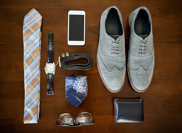 Одевайся для успеха. Высокий угол съемки стильного делового наряда и аксессуаров, выложенных на стол. - Фото, изображение