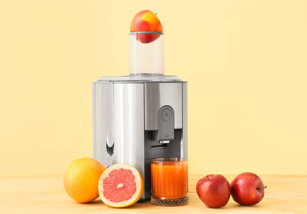 New modern juicer and glass of fresh juice with fruits on wooden table - Photo, Image