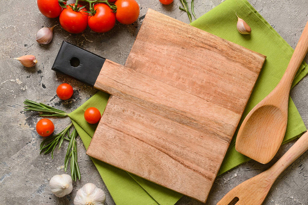 New cutting board with spices and tomatoes on grey background - Фото, изображение