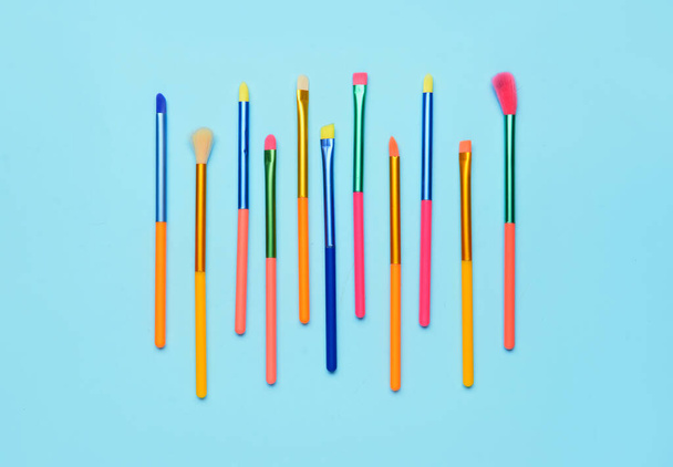 Set di pennelli trucco colorati su sfondo blu - Foto, immagini