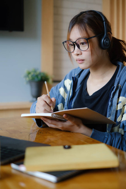 E-öğrenme, çevrimiçi, eğitim ve internet sosyal mesafesi COVID-19 virüs kavramından korunuyor. Asyalı kadın öğrenci video konferansı evde dizüstü bilgisayarda öğretmenle e-öğrenme. - Fotoğraf, Görsel
