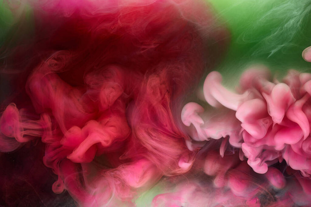 Green pink smoke on black ink background, colorful fog, abstract swirling touch ocean sea, acrylic paint pigment underwater - Fotografie, Obrázek