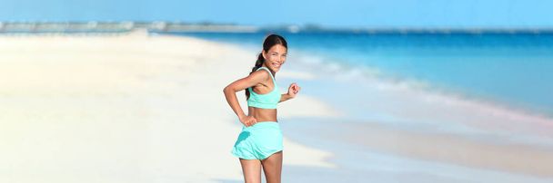 Happy running fitness girl looking back smiling on beach run jogging active healthy lifestyle. Asian woman athlete exercising cardio working out in summer outdoors - Fotó, kép