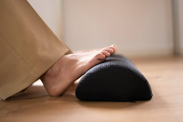 Worker Using Footrest To Reduce Back Strain And Feet Fatigue - Zdjęcie, obraz