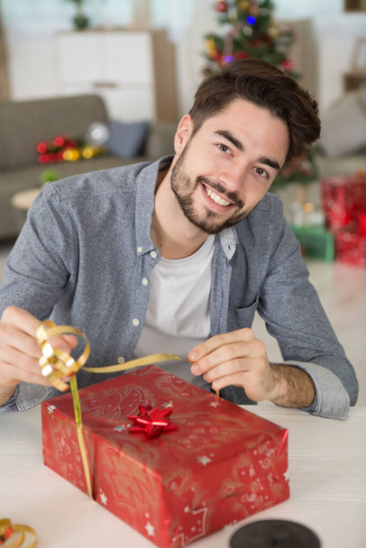 handsome guy in classic shirt preparing christmas gift - Фото, изображение