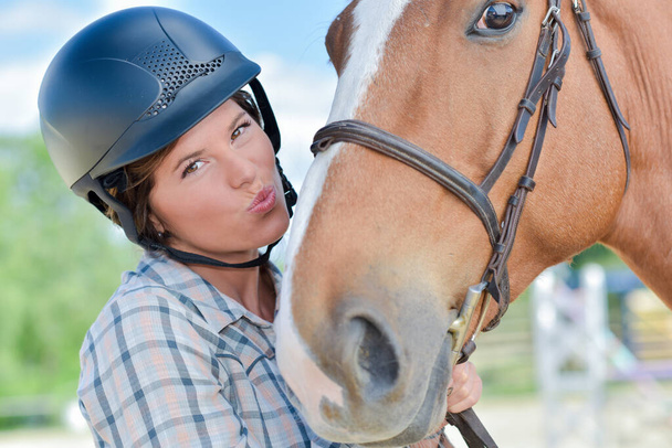 a smiling rider kissing a horse - Fotó, kép