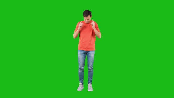 Δυσαρεστημένος άνθρωπος που καλύπτει αυτιά από θόρυβο. Πράσινο φόντο - Πλάνα, βίντεο