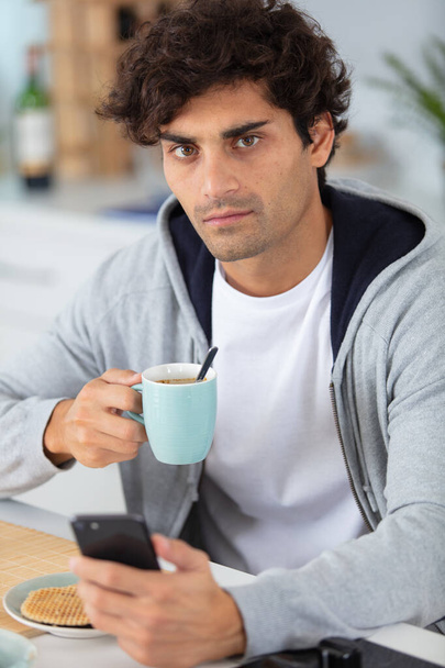 young man drinking a cup of coffee - Foto, afbeelding