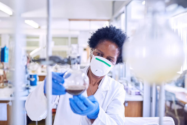 Working through the problem to uncover a solution. Shot of a female scientist working in a lab. - Foto, Imagen