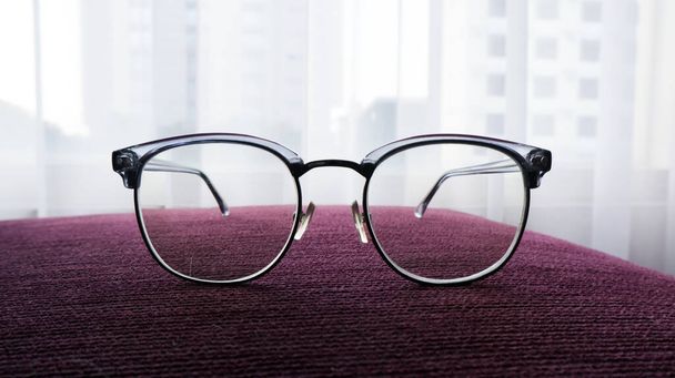 gray glasses on a purple background - Φωτογραφία, εικόνα