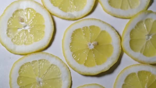 Background of sliced lemon rings, slices of fresh yellow lemons. - Materiał filmowy, wideo