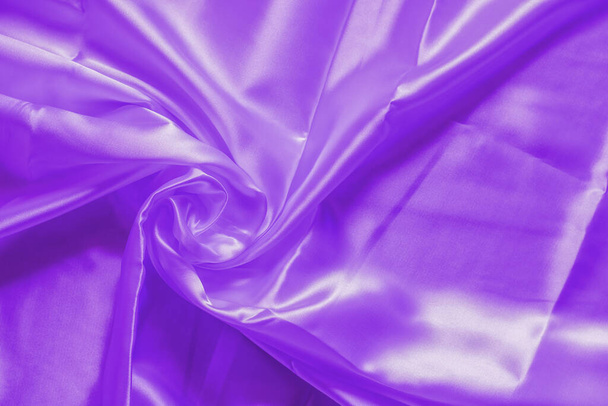 The wrinkled surface of the proton purple cloth. The purple shiny cloth. - Photo, Image