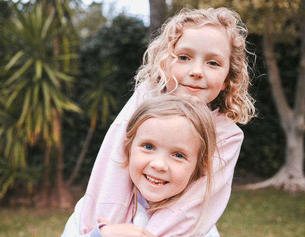 Kardeş sevgisi yukarıdan bir hediyedir. Bahçede eğlenen iki sevimli küçük kızın fotoğrafı.. - Fotoğraf, Görsel
