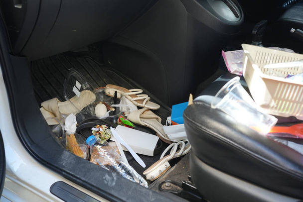 dirty car interior , carpet on the footwell has trash,food waste, dirt spilled across it. Needs to be cleaned and vacuumed inside . car maintenance concept - Photo, Image