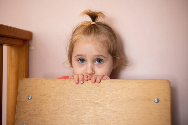 Üzgün mavi gözlü sarışın küçük bir kızın portresi. - Fotoğraf, Görsel