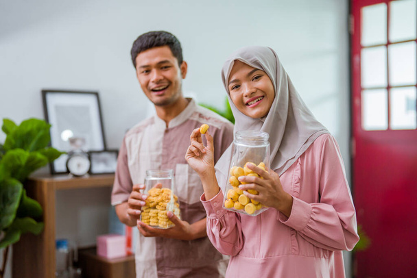 muslim couple holding idul fitri snack in the jar - Zdjęcie, obraz