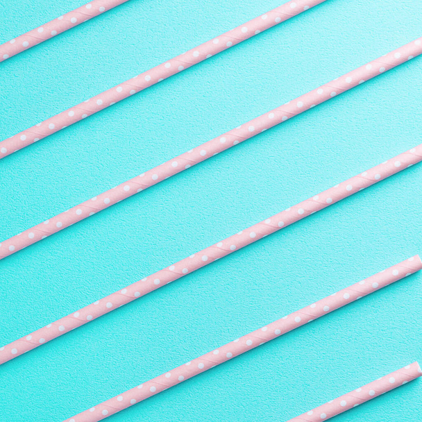 Biodegradable spotted pink paper straw set on blue table background, design concept of environmental protection for Earth Day. - Foto, afbeelding