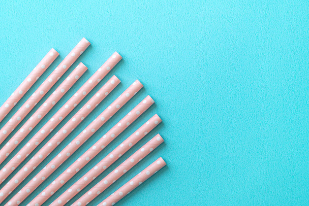 Biodegradable spotted pink paper straw set on blue table background, design concept of environmental protection for Earth Day. - Valokuva, kuva