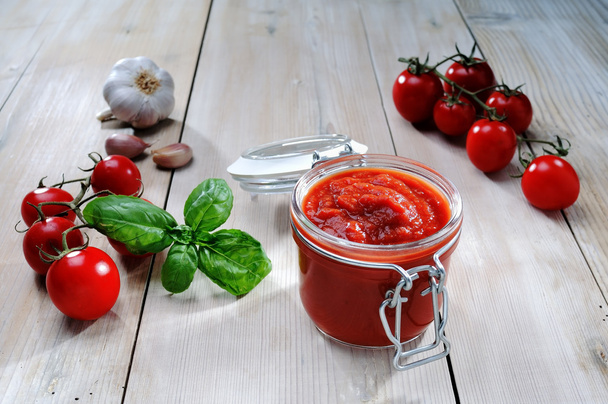 Purkki tomaattikastiketta valkoisella pöydällä
 - Valokuva, kuva