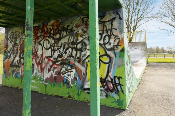 Newcastle-under-Lyme ,Staffordshire-united kingdom April, 11, 2022 Graffiti covered skateboard halfpipe at Lyme valley parkway - Фото, зображення