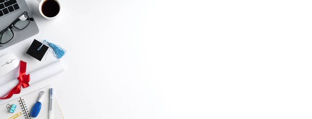 Top pohled na online učení a dálkové promoce slavnostní zahájení designu koncept s absolventy akademické čepice, diplom a notebook na bílém stole pozadí. - Fotografie, Obrázek