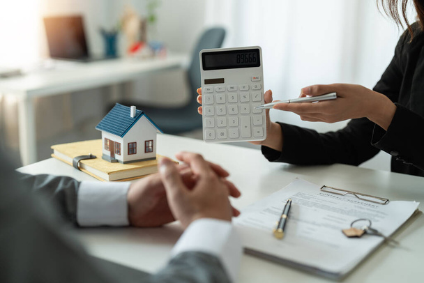 Real estate agent showing financial rate home loan for sign agreement customer the contract legally, Home sales and home insurance concept. - Photo, Image