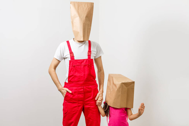 man en klein meisje met pakketten op hun hoofd - Foto, afbeelding
