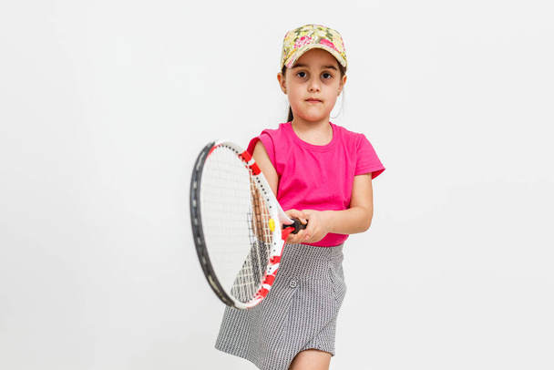 Nettes kleines Mädchen mit Tennisschläger auf weißem Hintergrund. - Foto, Bild