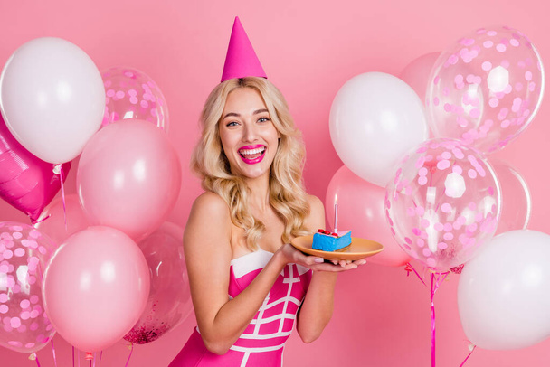 Photo of funny lady hold cake piece dish have birthday fun wear cone hat fancy striped dress isolated pink color background - Fotó, kép
