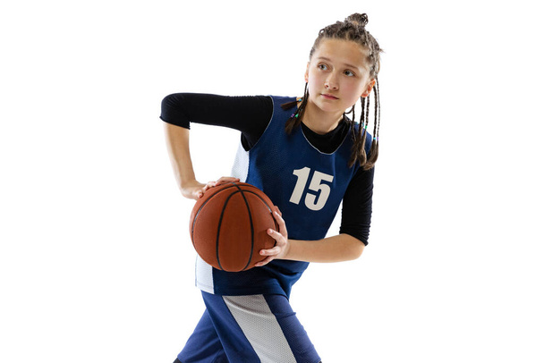 Portrait of teen girl in motion, basketbal player training isolated over white studio background - 写真・画像