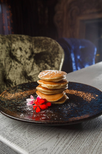 American pancakes with berries and maple syrup on black plate isolated with coffee. cafe menu. - Фото, зображення