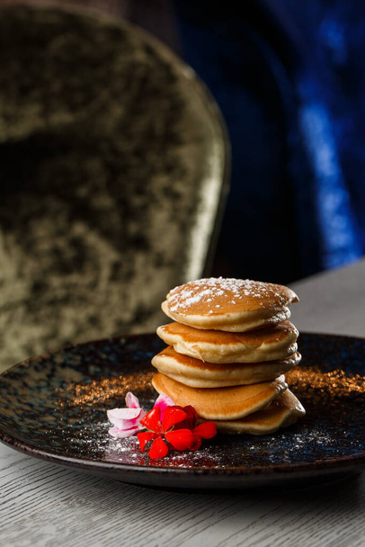 American pancakes with berries and maple syrup on black plate isolated with coffee. cafe menu. - Photo, image