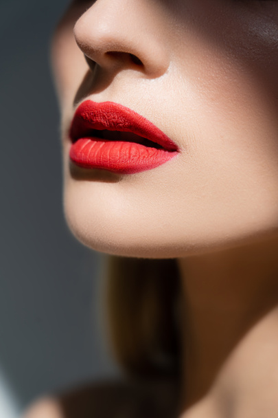 Cropped view of woman with red lips isolated on grey  - Фото, изображение