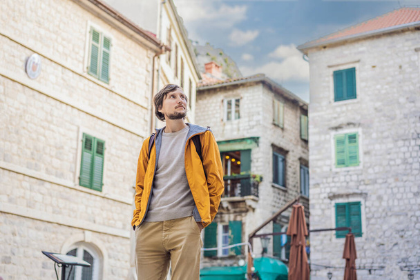 Man tourist enjoying Colorful street in Old town of Kotor on a sunny day, Montenegro. Travel to Montenegro concept - Foto, Bild