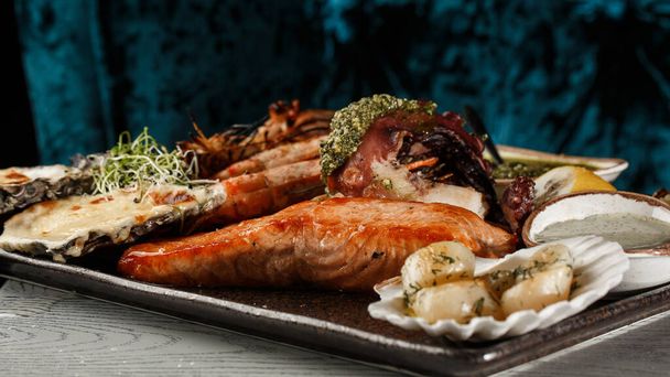 Roasted Mixed Seafood Contain Mussels, prawns, salmon, Calamari Squids and Grilled Barracuda Fish Garlic with Spicy Chili Sauce. Seafood and meat platter. - Valokuva, kuva