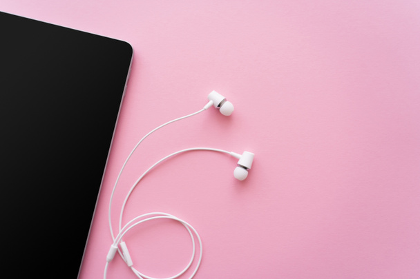 top view of digital tablet with blank screen near earphones on pink - Фото, изображение