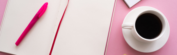 vista superior de la pluma en el cuaderno abierto cerca de la taza de café y portátil en rosa, bandera - Foto, imagen