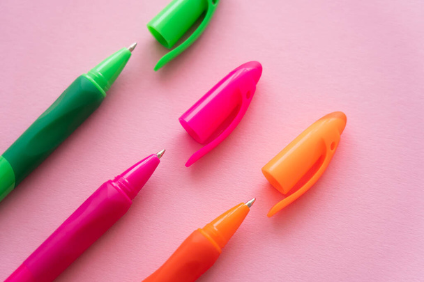 Draufsicht auf helle und bunte Kugelschreiber auf rosa  - Foto, Bild