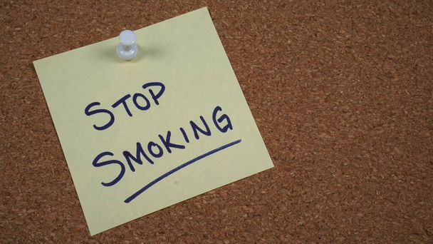 Odręczna notatka umieszczona na tablicy korkowej z przypomnieniem o rzuceniu palenia - Zdjęcie, obraz