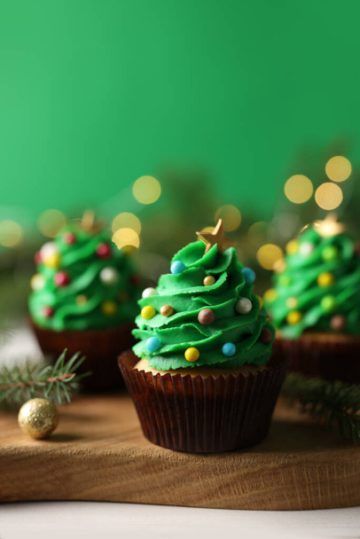 Tasty Christmas cupcakes on wooden board, closeup - 写真・画像