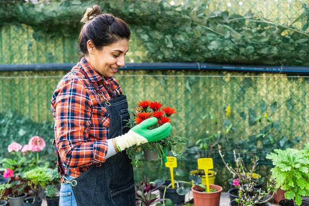 植物や花の庭の店で働く幸せな女性 - 写真・画像