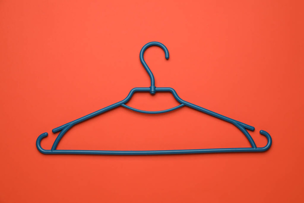 Empty clothes hanger on red background, top view - Fotó, kép